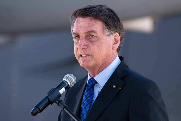 man in suit speaking at a microphone