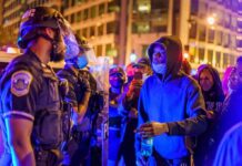 PM Bans ALL Public Gatherings – Curfew in Effect! Protesters talk with police officers at night in city street
