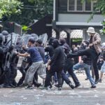 Dem Candidate Shoved to the Curb During Protest Protesters clash with riot police holding shields