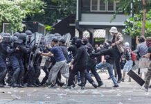 Dem Candidate Shoved to the Curb During Protest Protesters clash with riot police holding shields