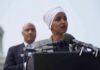 Ilhan Omar speaking at a podium with André Carson standing behind