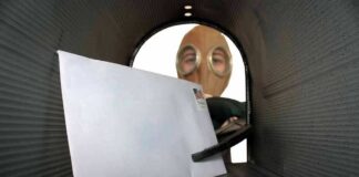 Letter inside a mailbox with a person wearing a gas mask outside