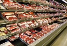 supermarket meat section with packaged cuts in refrigerated shelves