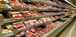 supermarket meat section with packaged cuts in refrigerated shelves