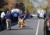 Police officers and investigators at a blocked city street scene