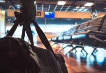 duffel bag in foreground at empty airport gate seating